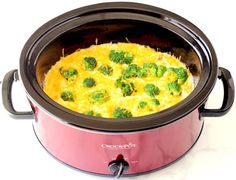 a crock pot with broccoli and cheese in it sitting on a table