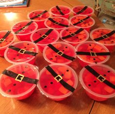 many plastic containers filled with candy sitting on top of a wooden table