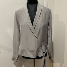 Elevate Your Wardrobe With This Stunning J Brand Blouse. Made From 100% Silk, Size Medium, And In A Gorgeous Light Gray Color. The Long Sleeves And V-Neckline Are Complemented By A Front Tie Closure, Adding A Touch Of Elegance To Any Outfit. Perfect For Work Or Any Occasion! Retailed For $248 + Tax! Chic Silver V-neck Top, Gray V-neck Blouse For Workwear, Gray V-neck Blouse For Work, Gray Tops For Spring Evening, Gray Tops For Evening In Spring, Elegant Gray Long Sleeve Tops, Elegant Long Sleeve Gray Tops, Silver Long Sleeve Tops For Spring, Fall Season Silver V-neck Top