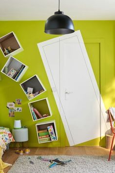 a room with green walls and white doors, bookshelves on the wall next to a bed