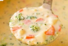 broccoli, carrots and cheese soup in a pot with a ladle