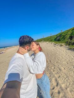 a man and woman kissing on the beach