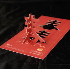 a piece of red paper with chinese writing on it and an image of a tree