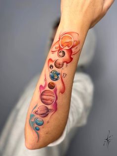 a person with a tattoo on their arm that has planets and stars all over it