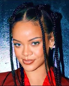 a close up of a person with long braids on her head and wearing a red shirt