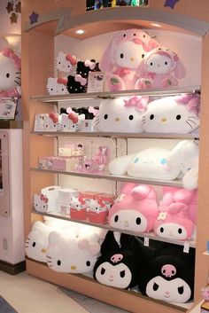 hello kitty stuffed animals are on display in a store with pink and white colors,