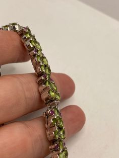 This Peridot and Ruby bracelet is very lively and bright. The stones are deep colors and well matched. The sterling silver is plated with rhodium to protect the bracelet from tarnish and give the appearance of white gold. My jeweler can shorten this for a $20 fee 7.5 inches All jewelry is shipped in a nice gift box. Check out our over a THOUSAND great reviews!!! Engraving is $4 per letter and is not always perfect depending on the piece. It can take a few days if the jeweler is busy. This is pay Sterling Silver Fine Jewelry Bracelets With Stones, Luxury Multi-stone Peridot Jewelry, Luxury Peridot Multi-stone Jewelry, Sterling Silver Gemstone Tennis Bracelet, Sterling Silver Multi-stone Round Bracelet, Sterling Silver Multi-stone Bracelets, Luxury Sterling Silver Bracelets With Stones, Luxury Hallmarked Peridot Jewelry, Silver Multi-stone Tennis Bracelet For Formal Occasions