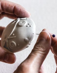 two hands holding an object in the shape of a skull