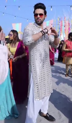 a man standing in front of a group of people wearing white clothing and holding something