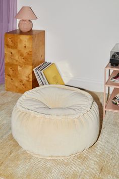 a living room with a large round bean bag chair and small end table in the corner