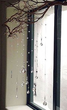 a bathroom with a tree branch hanging over the bathtub, and glass beads on the shower curtain