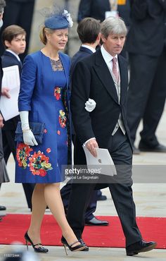 the man and woman are walking down the red carpet