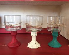 three glass bowls with rope wrapped around them on a red countertop in front of a white wall