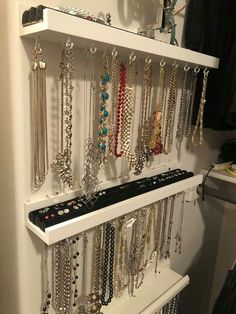 a white shelf filled with lots of necklaces and bracelets on it's sides