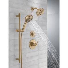 the shower head and handset are shown in this bathroom setting with gold faucets