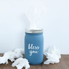 a blue mason jar with tissue paper in it and the words, blessing you on it