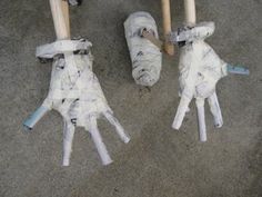 three baseball bats that have been made out of toilet paper and are sitting on the ground