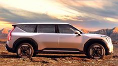 a white suv parked on top of a rocky field