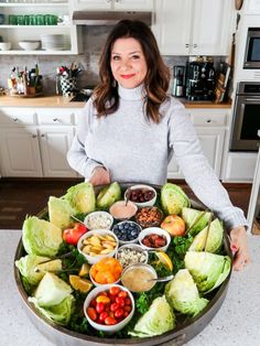 a woman is holding a platter full of food