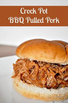 the crock pot bbq pulled pork sandwich is on a white plate with text overlay