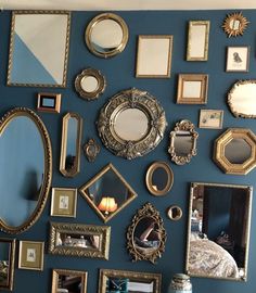 there are many mirrors on the wall and one is blue with gold trimmings