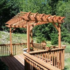 a wooden deck with an arbor and potted plants