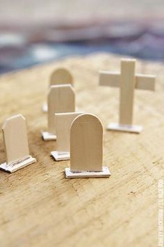 small wooden crosses are placed on top of a piece of wood