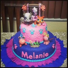 a birthday cake decorated with littlest pets and name melanie on the top