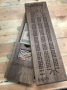 a wooden board with holes in the middle and money sticking out of it's hole