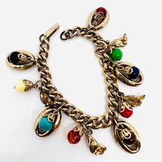 Excellent Vintage Multicolored Glass Beaded Dangling Flowers Charm Bracelet. Gold tone metal with dangling filigree capped glass beads and oval hoops with flowers. In great vintage condition with age appropriate wear. No chips or cracks. Measures 1 inch wide at widest point and is 7 1/4 inches long. Fold over clasp secure Dangling Flowers, Charm Bracelet Vintage, Charm Bracelet Gold, Vintage Designer Jewelry, Vintage Charm Bracelet, Bracelet Vintage, Vintage Designer, Bracelet Gold, Beaded Dangles