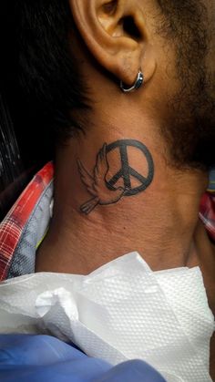 a man with a peace sign tattoo on his neck and behind his ear is another person's head