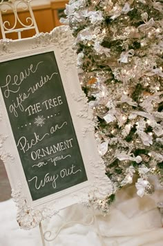 a chalkboard sign is next to a christmas tree