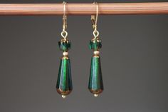 "Emerald Green Earrings / Czech Glass Earrings / Dangle Drop Earrings / Teardrop Earrings / Christmas Gift for women / Gift for her These dangle earrings feature beautiful emerald green and gold teardrop Czech glass beads and are finished off with gold plated leverback and findings. At just 1 3/4 inches long, these earrings are the perfect accessory for any outfit and perfect during Christmas time. Design, color and faceted glass beads gives to these earrings a lovely vintage style. Shine in the light ! Color : Emerald Green and gold Faceted and translucide Teardrop Czech glass beads. Finish : Gold plated lever back and findings Length : 1 7/8 inches including antique brass lever back For more choices on my Czech glass Earrings, please refer to the link below : https://www.etsy.com/shop/Nt Rustic Green Dangle Jewelry, Rustic Green Dangle Earrings, Green Bohemian Drop Earrings, Unique Green Czech Glass Earrings, Green Czech Glass Drop Earrings, Emerald Green And Gold, Emerald Green Earrings, Boho Chic Earrings, Rustic Earrings