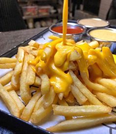 a tray with french fries covered in cheese