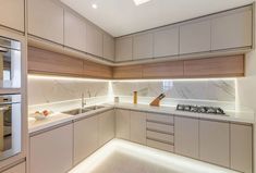 a kitchen with white cabinets and marble counter tops, along with an oven in the center