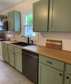 a kitchen with green cabinets and wooden counter tops