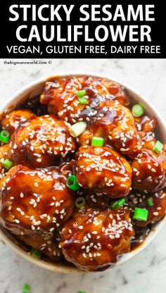 a bowl filled with sticky sesame cauliflower and topped with green onions