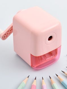 a pink sharpener with colored pencils around it