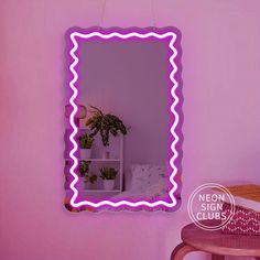 a mirror that is on the wall next to a table with a potted plant