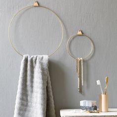 two towels are hanging on the wall next to a towel rack and toothbrush holder