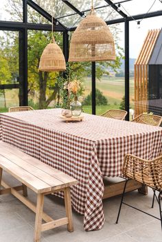 a table with a checkered cloth on it next to some chairs and a bench