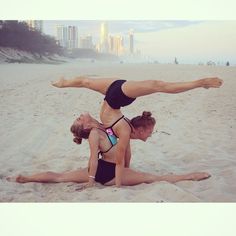 two women doing acrobatic exercises on the beach