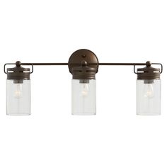 three light fixture with clear glass jars hanging from the wall, on an old - fashioned bronze finish