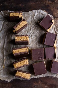 several pieces of chocolate and peanut butter fudge cake on top of parchment paper with one slice cut out