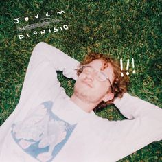 a man laying in the grass with his eyes closed