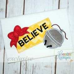 a white towel with a red bow and a bell on it that says believe next to the tag