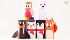 some paper roll animals are standing next to each other on a white surface and one is wearing a top hat