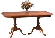 a wooden table topped with a vase filled with flowers on top of an oval dining room table