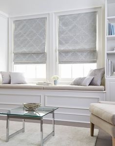 a living room filled with furniture and windows covered in roman blind shades on the windowsill