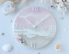 a clock that is sitting on top of a table next to shells and seashells